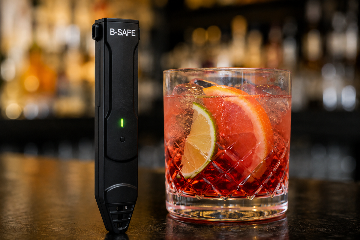 B-SAFE détecteur de drogues dans les boissons à côté d’un cocktail en soirée